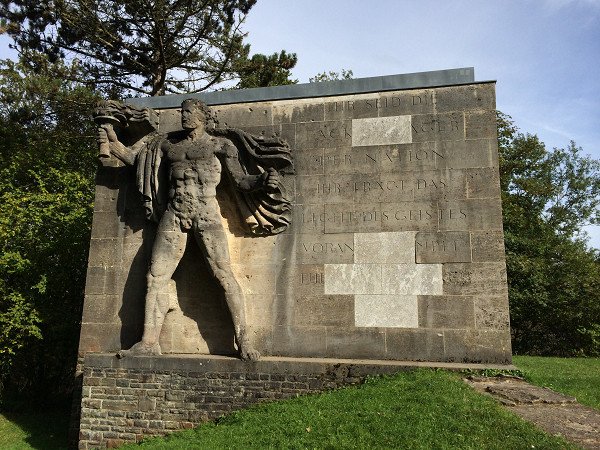 NS-Ordensburg Vogelsang, 2014, Der Fackelträger auf dem »Sonnwendplatz« auf der Burg Vogelsang im heutigen Zustand mit zahlreichen Einschusslöchern, Gemini79 / Wikimedia Commons