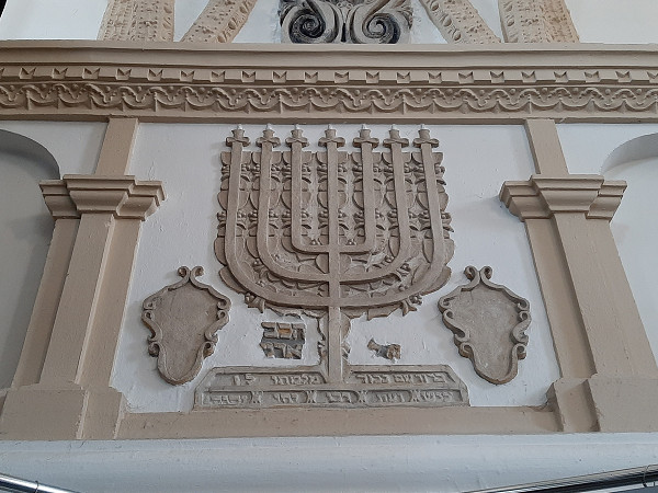 Szczebrzeszyn, 2021, Eine Menorah an der Wand in der ehemaligen Synagoge, Stiftung Denkmal